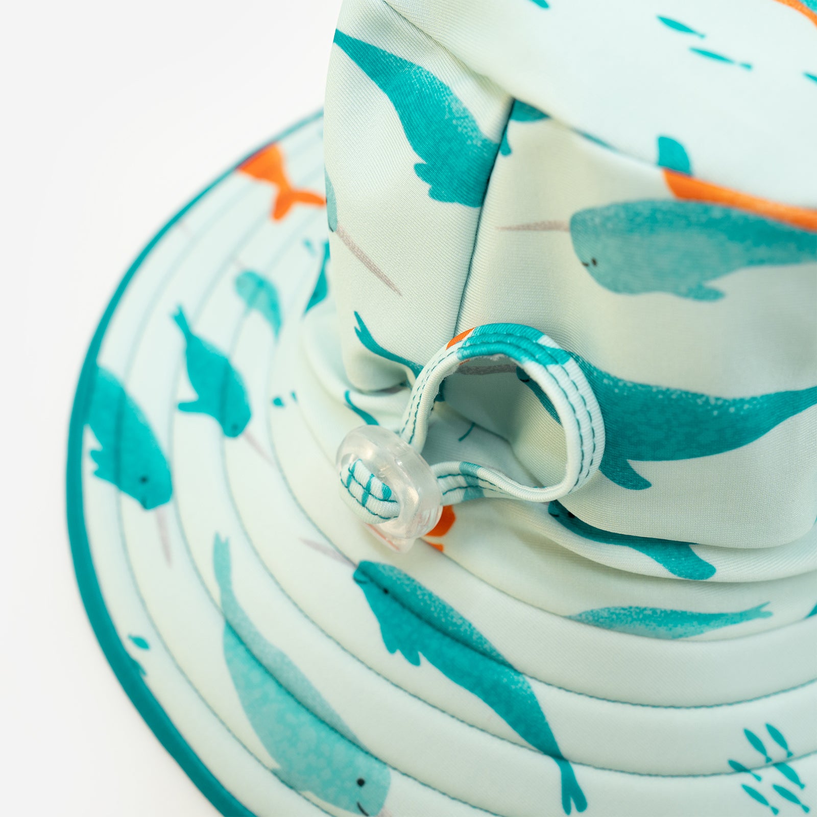 Close up of adjustable head toggle of Pipi Swimwear aqua and narwhal reversible wide brim swim hat