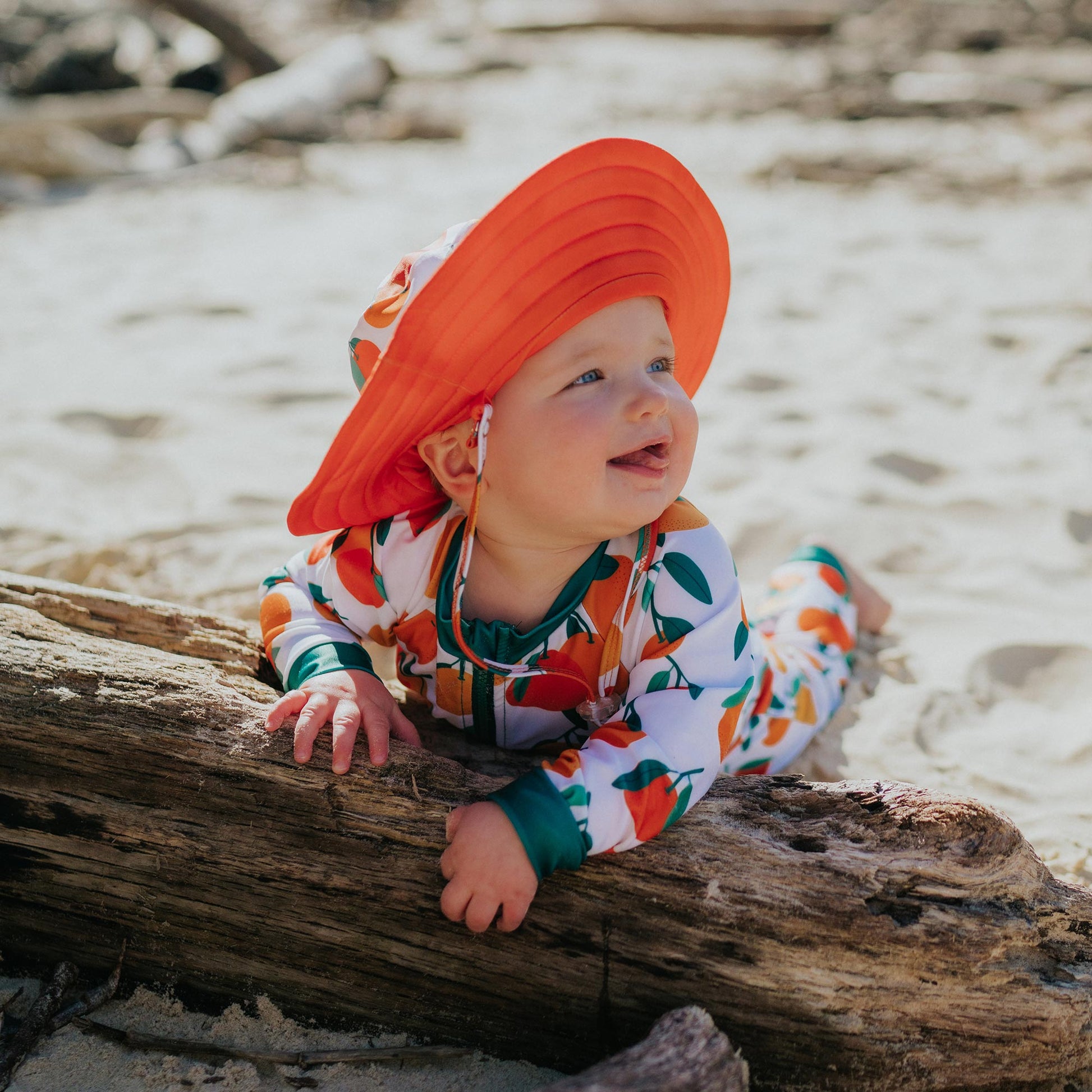 Baby wearing Pipi Swimwear citrus fruit full length sunsuit and matching wide brim swim hat