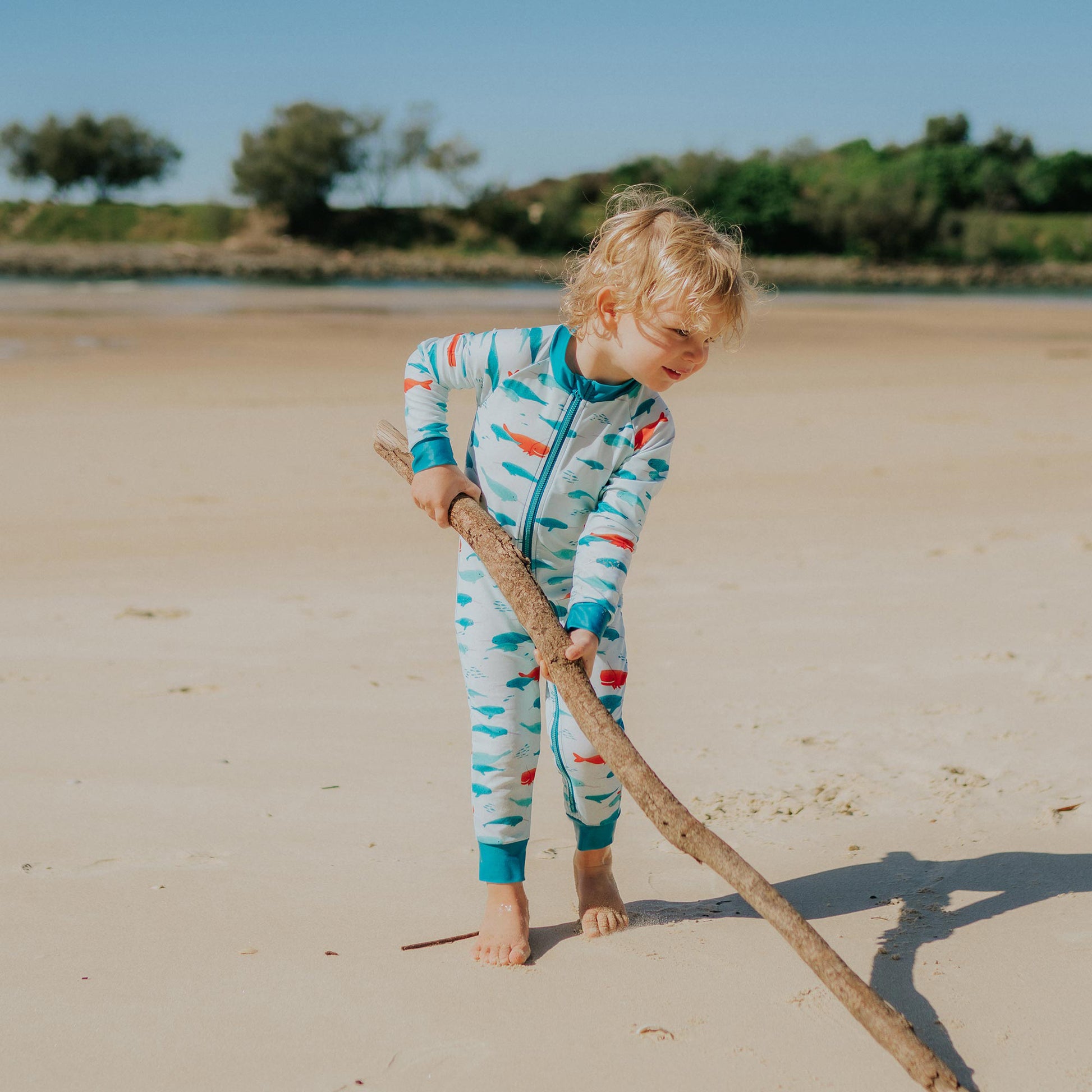 Toddler wearing Pipi Swimwear narwhal full length sunsuit