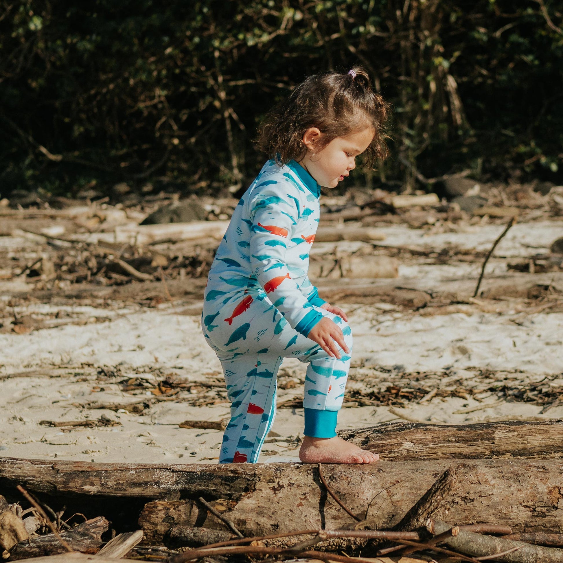 Toddler wearing Pipi Swimwear narwhal full length sunsuit