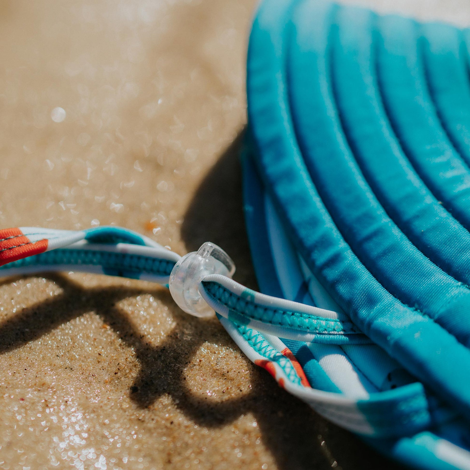 Adjustable chin strap of Pipi Swimwear aqua and narwhal pattern reversible wide brim swim hat