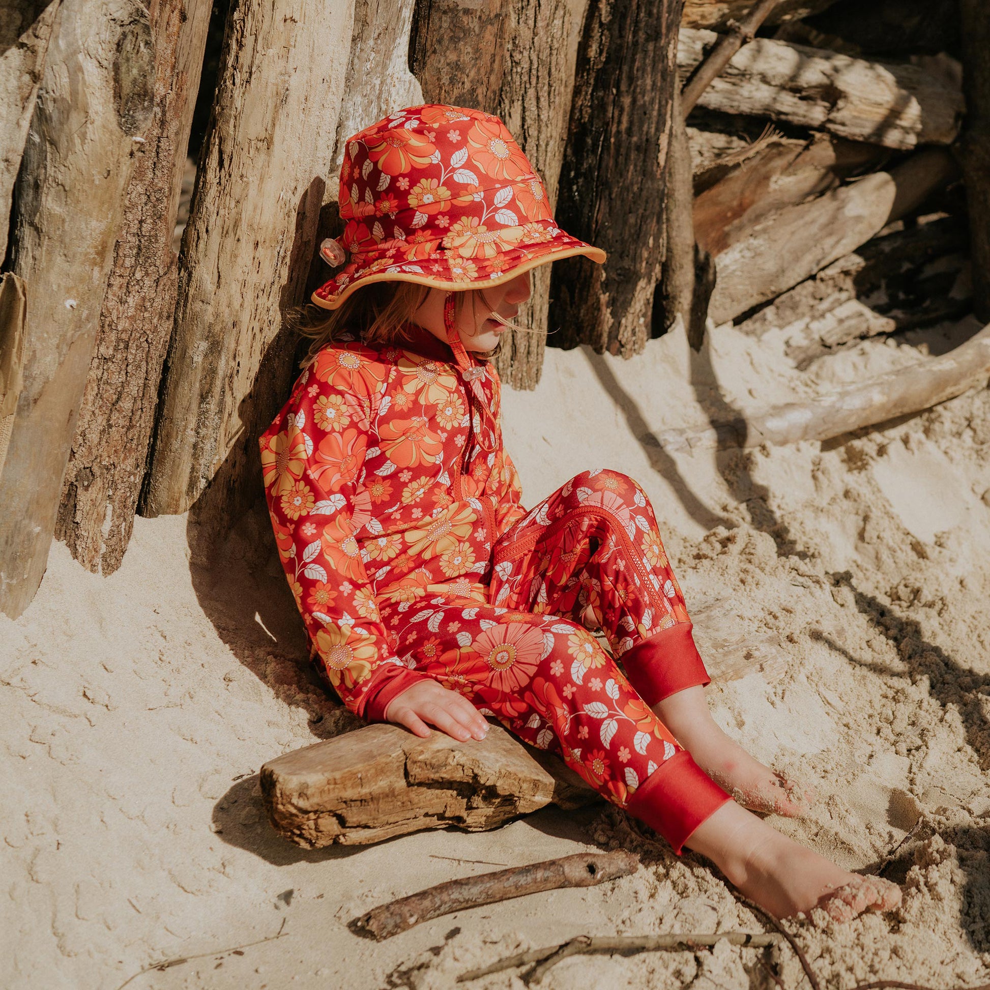 Toddler wearing Pipi Swimwear floral full length sunsuit and matching wide brim swim hat