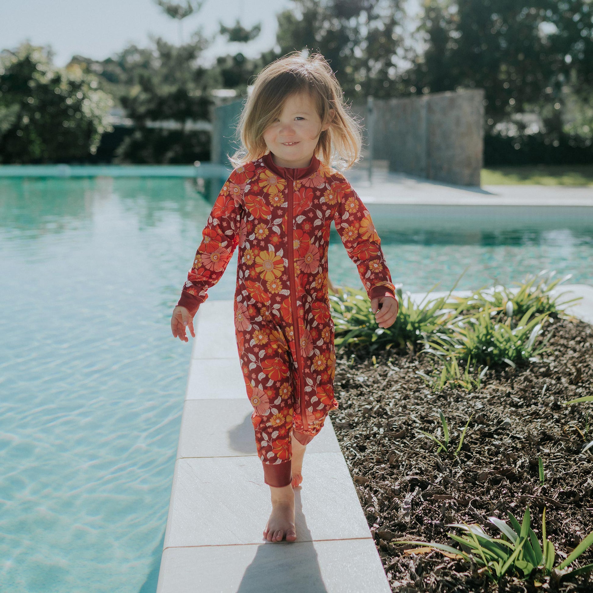 Toddler wearing Pipi Swimwear floral full length sunsuit